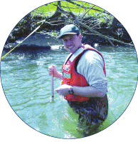 USGS scientist collecting sediment samples. [Photo by John R. Gray, U.S. Geological Survey] (Click to view larger image.)
